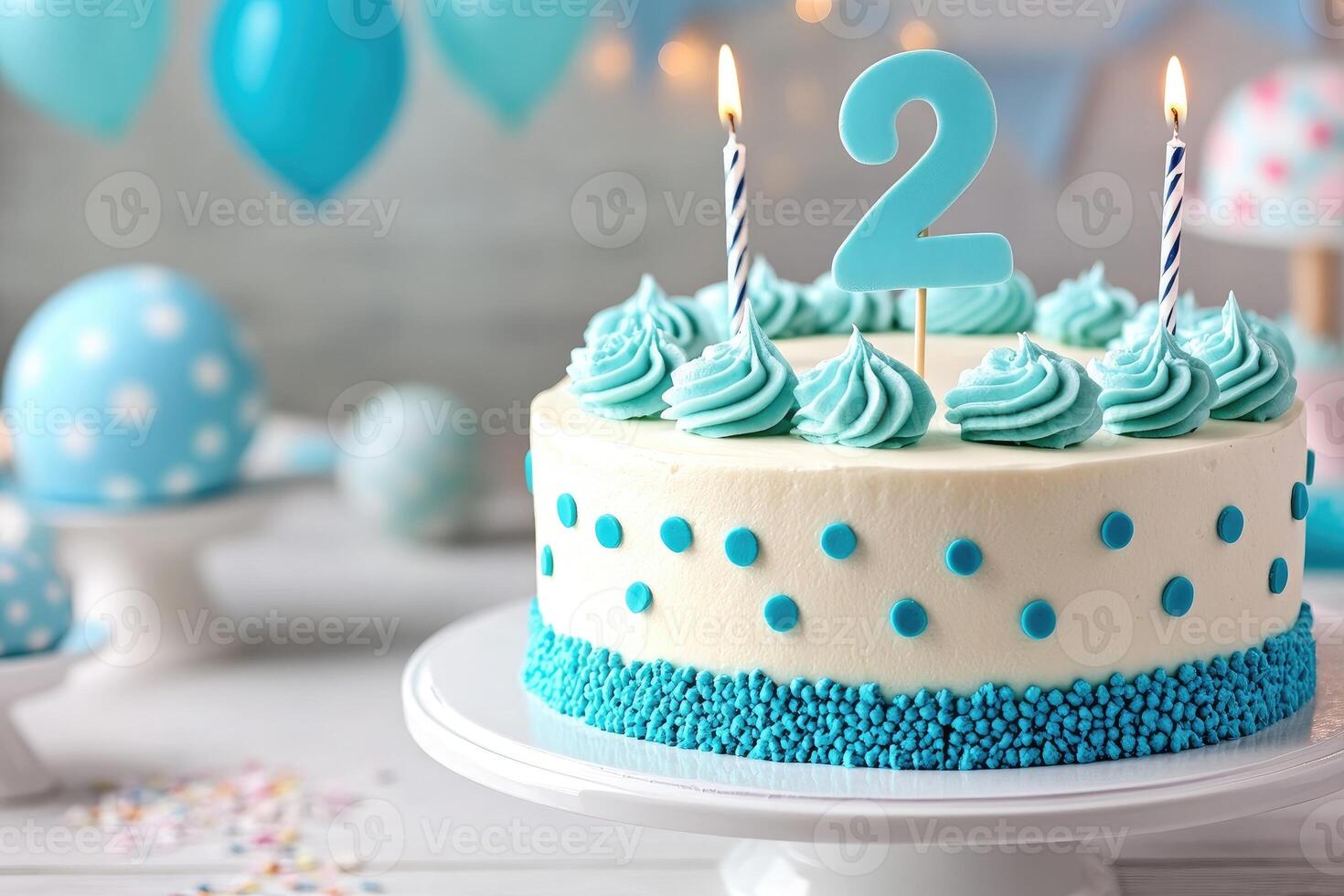 Delicious cake celebrating second birthday with lit candles and blue decorations photo