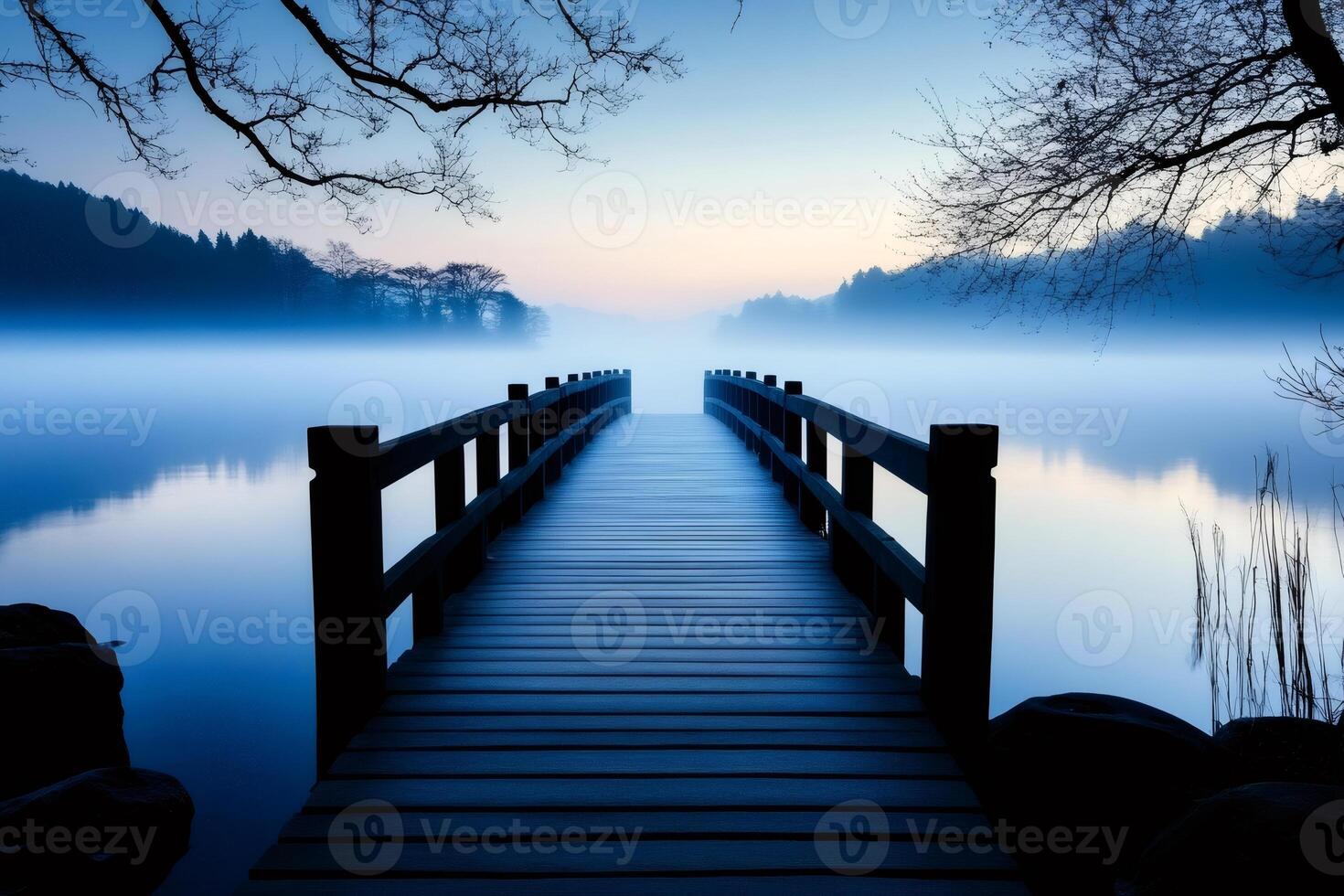 Wooden pier stretching into misty lake at dawn photo