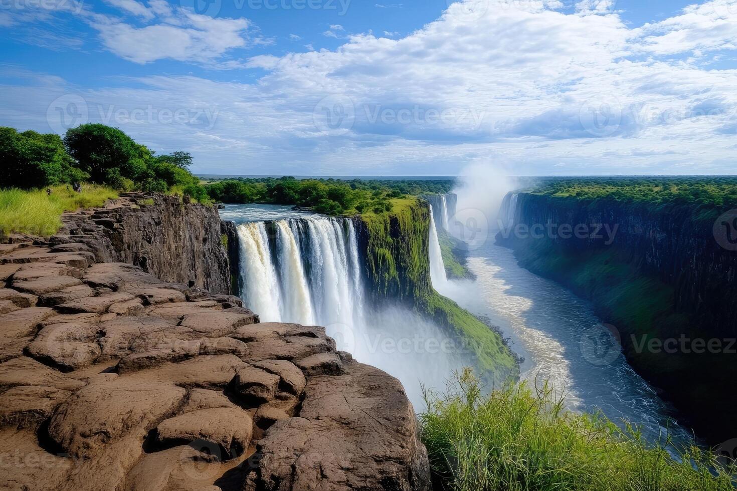 Victoria falls cascading into zambezi river gorge on sunny day photo