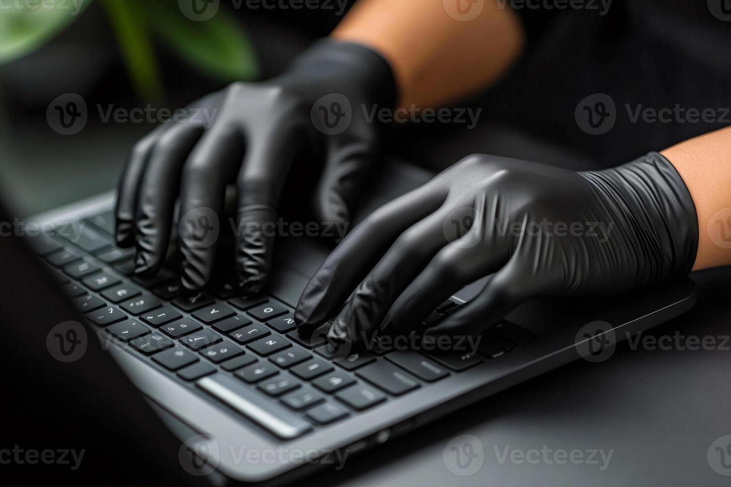 Hacker typing on laptop keyboard wearing black gloves, cybersecurity threat photo
