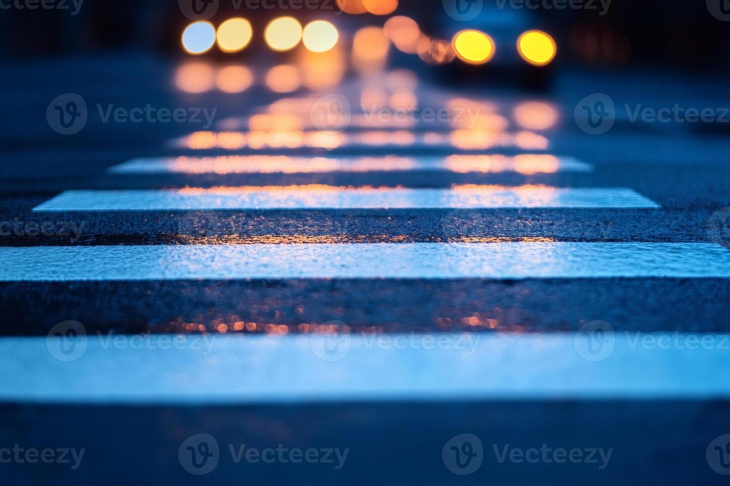 Wet crosswalk reflecting city lights at night photo