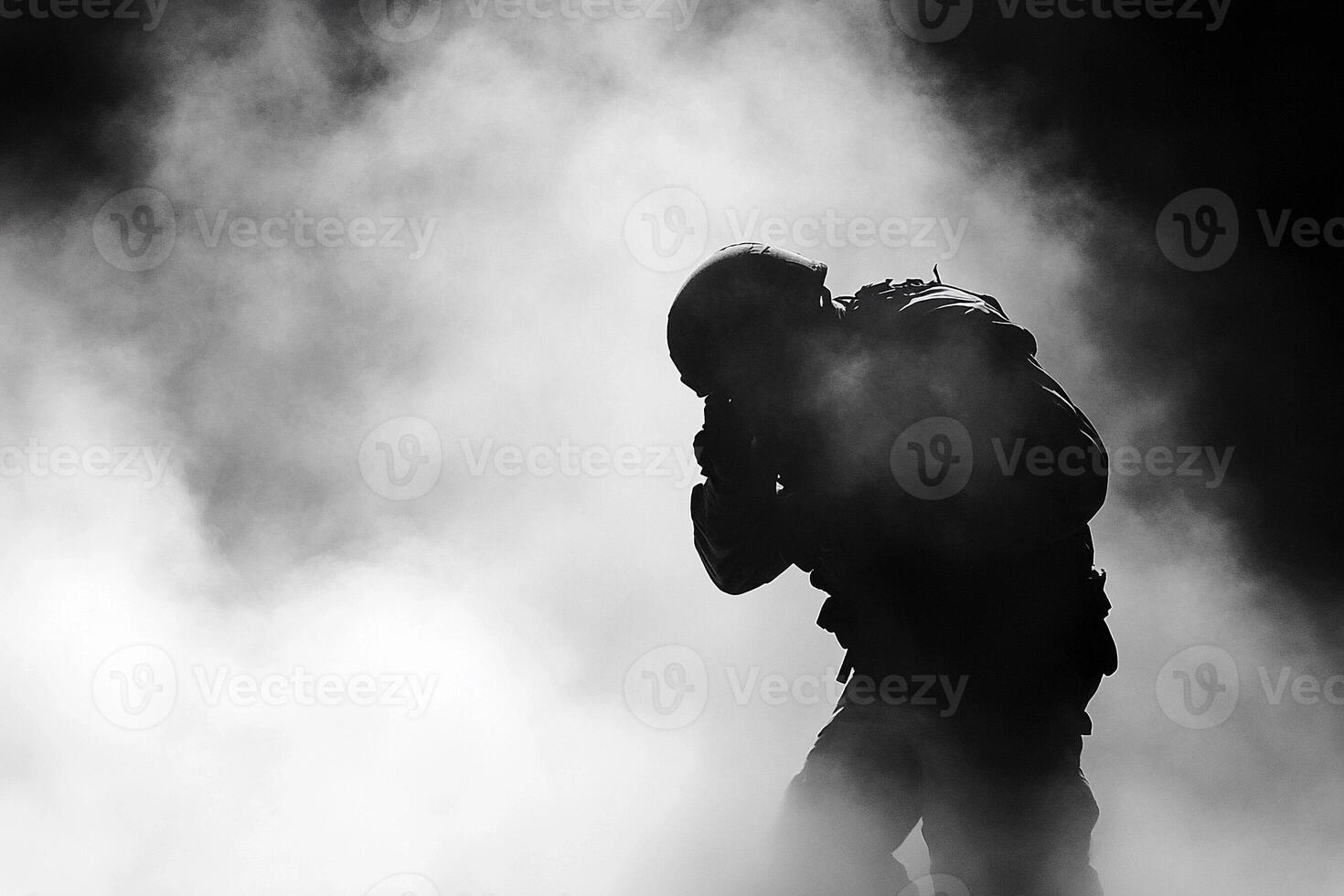 A man is silhouetted in the smoke of a fire photo