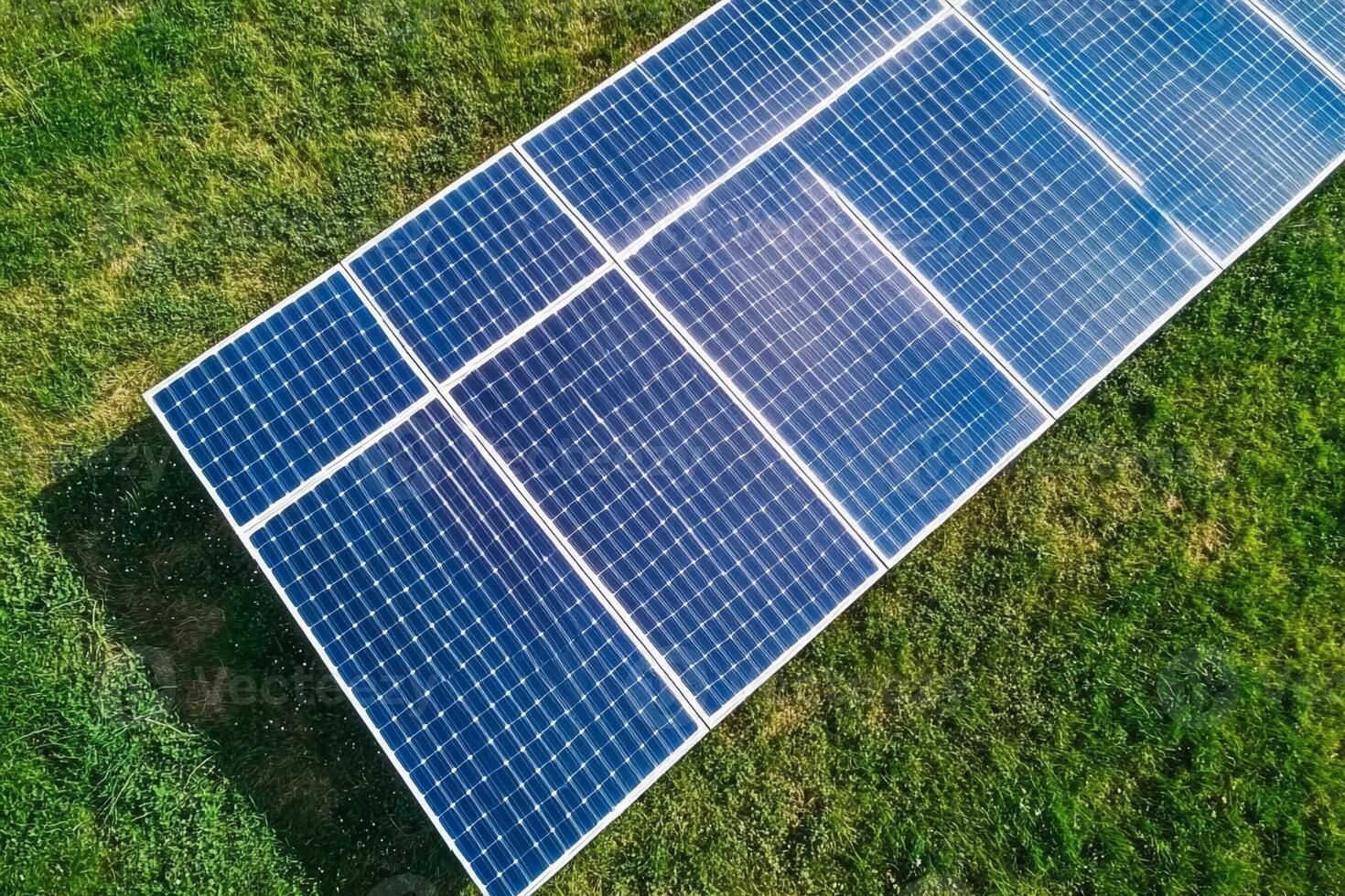 An aerial view of a solar panel on a green field photo