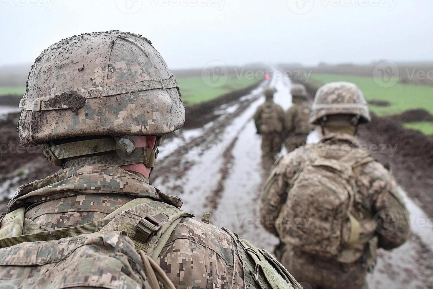 Us soldiers walk along a muddy road photo
