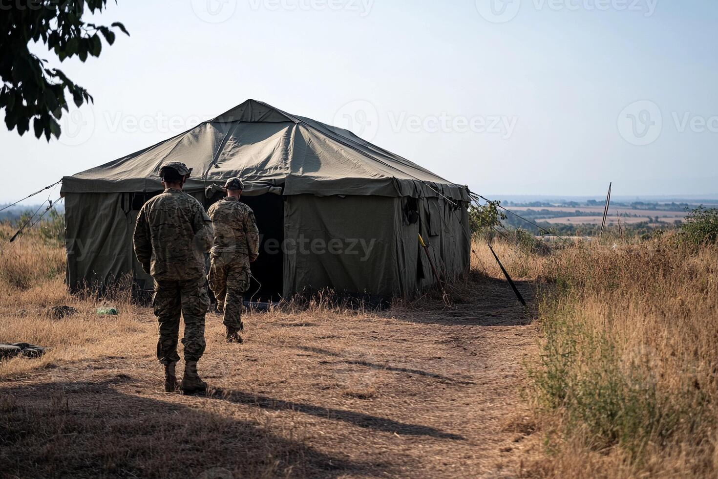 Two soldiers walking towards a tent in the field photo