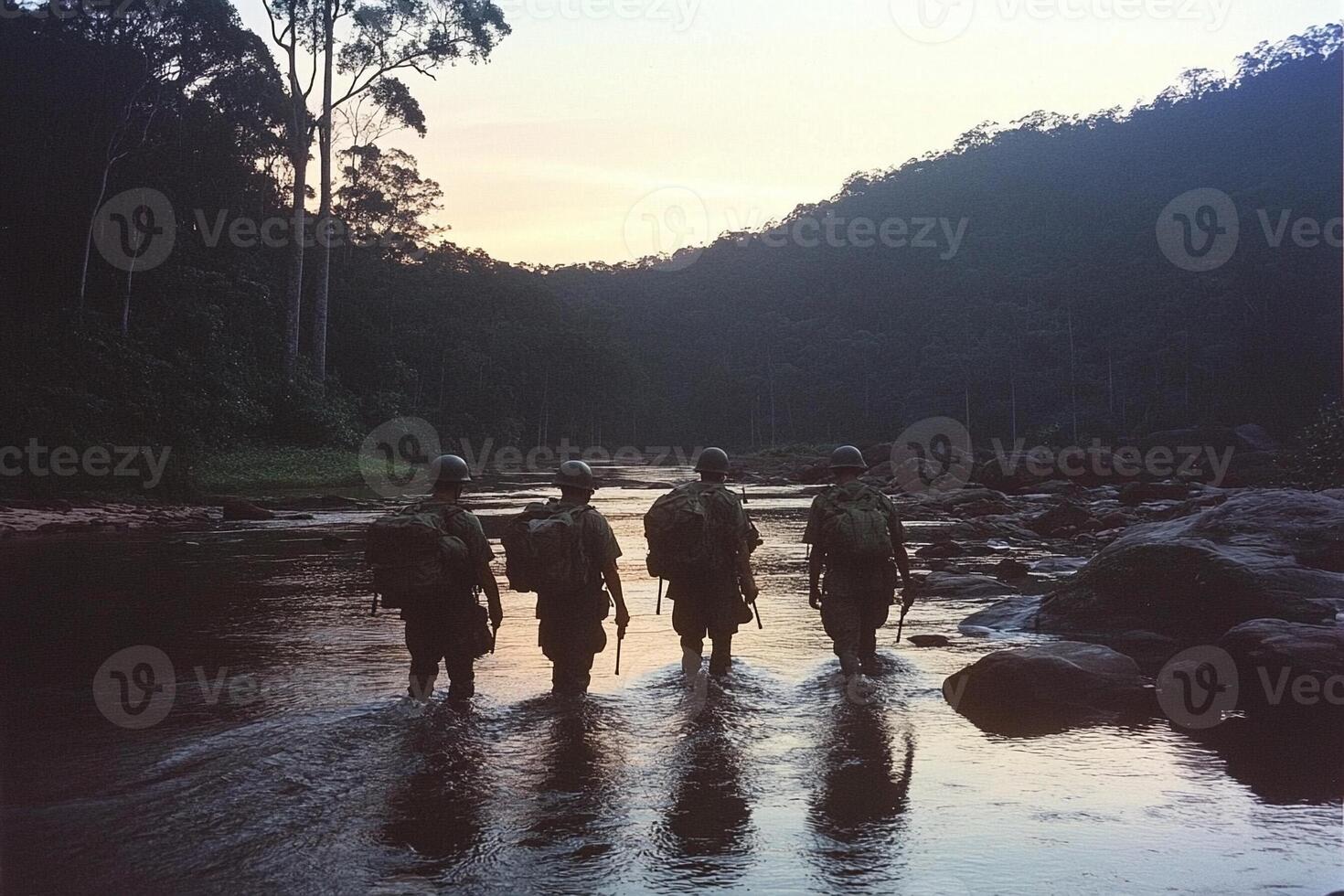 Three soldiers walking across a river at sunset photo