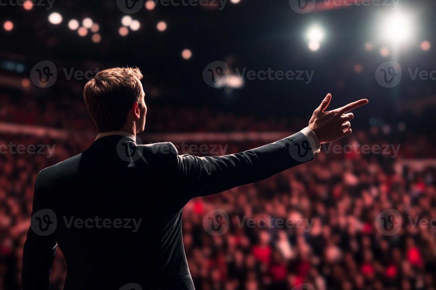 A man in a suit is pointing at an audience photo