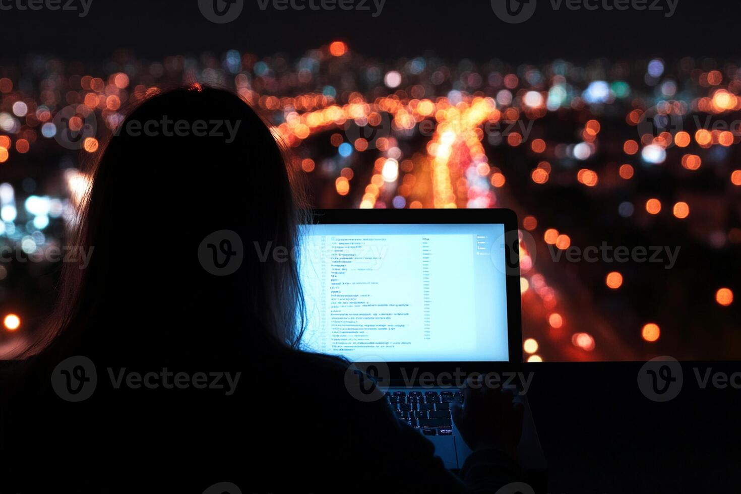 A person sitting at a desk with a laptop computer in front of them photo