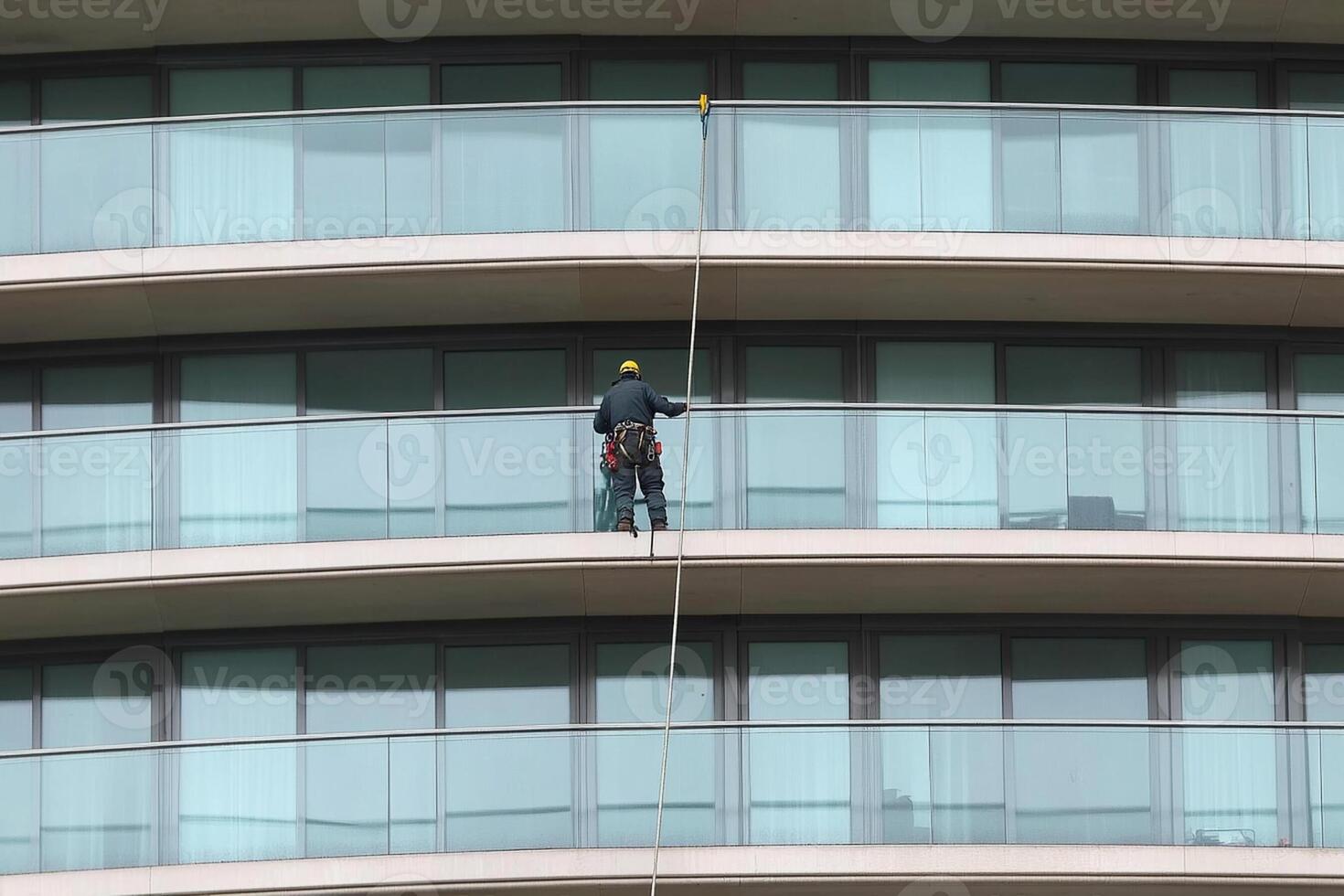 A man on a rope cleaning the windows of a tall building photo