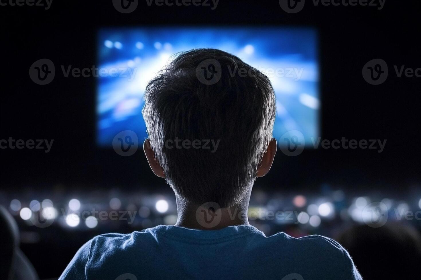 A boy is watching a movie in a theater photo