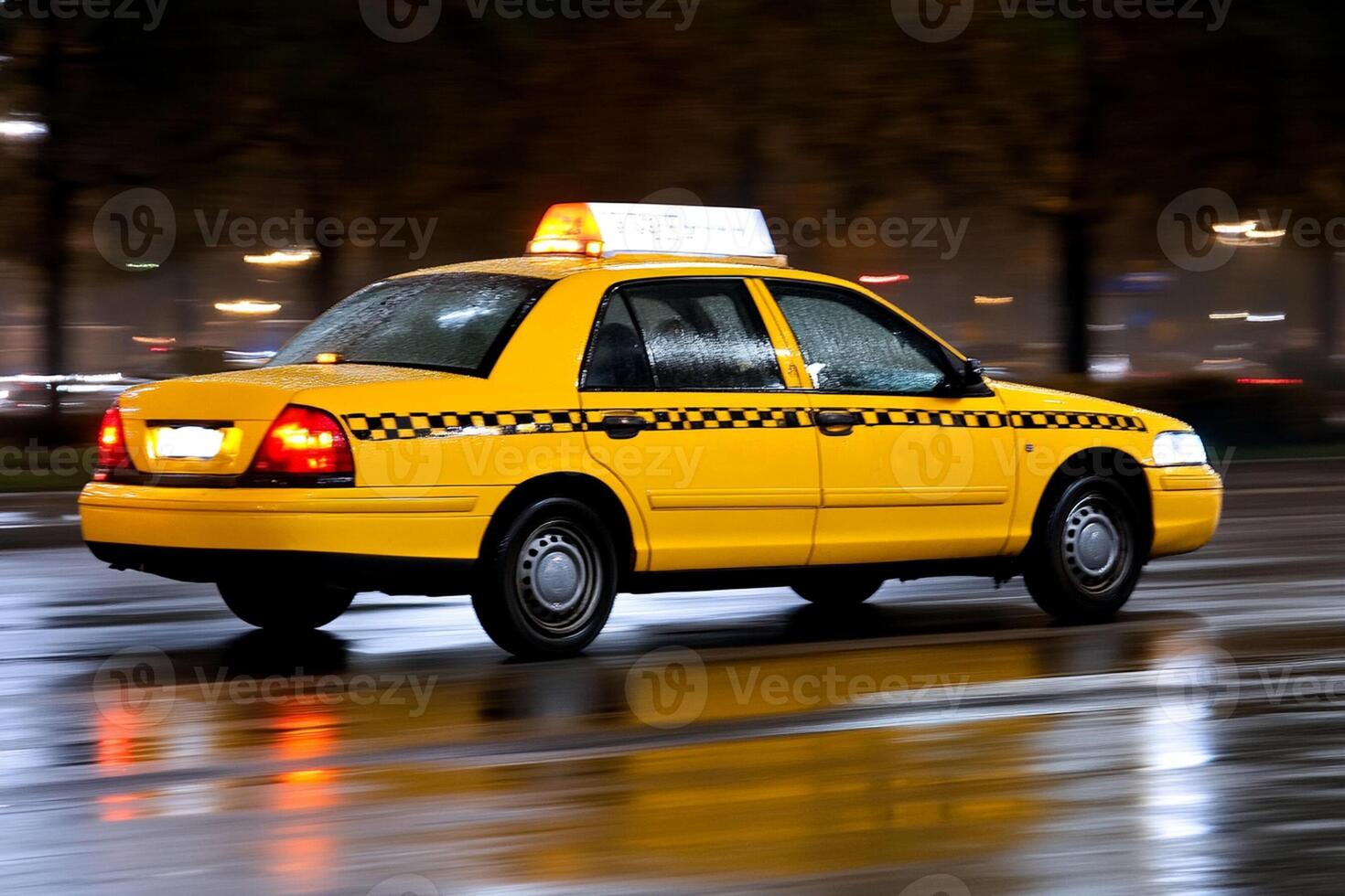 A taxi cab driving down a wet street at night photo