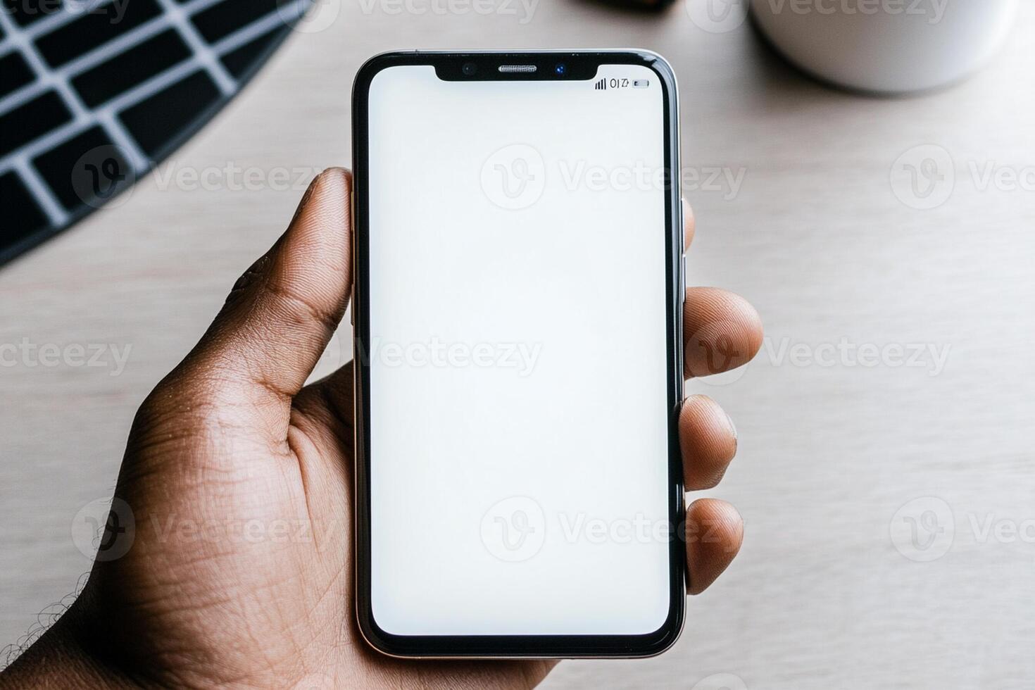 A hand holding an iphone xs with a blank screen photo