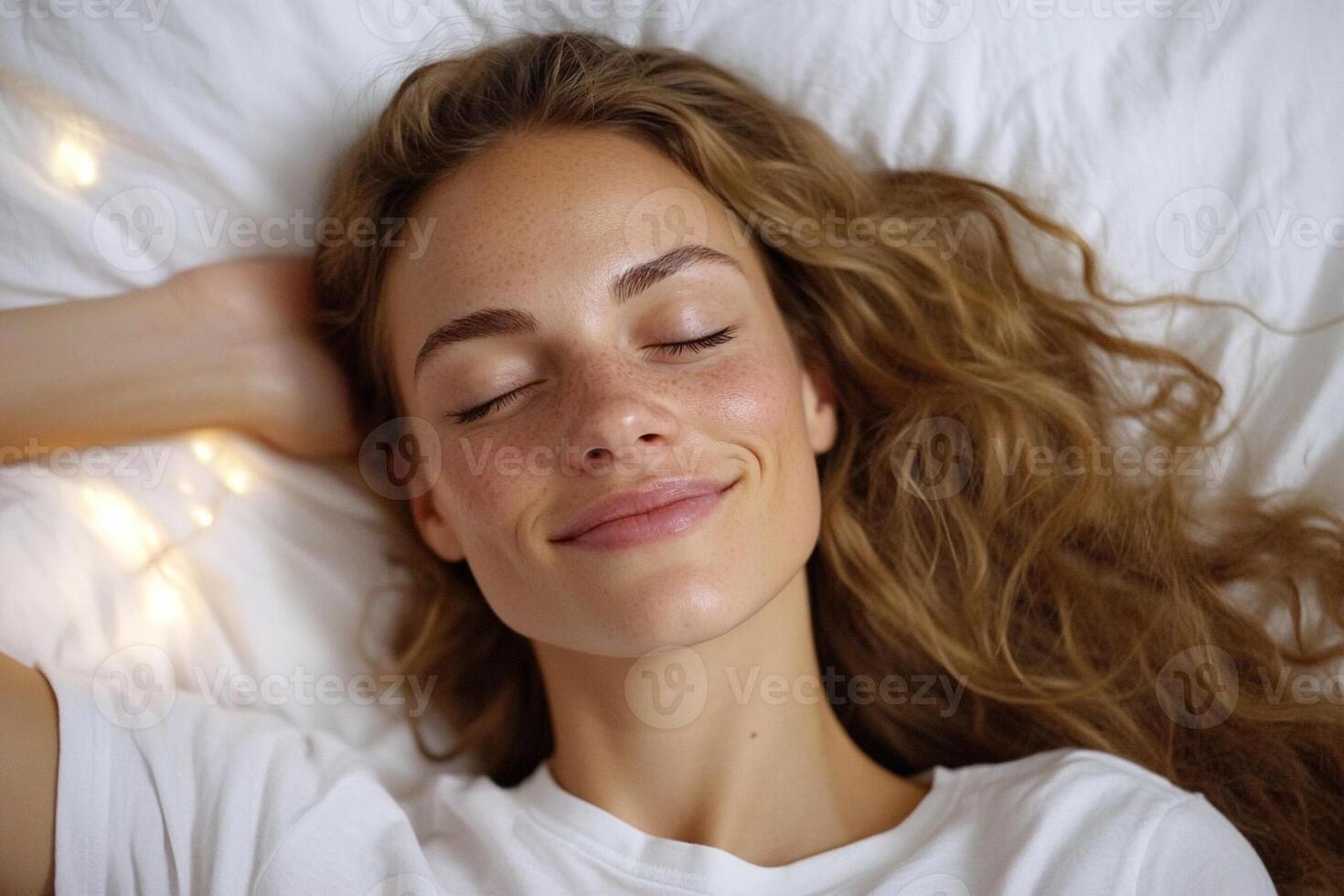 A woman is smiling while laying in bed photo