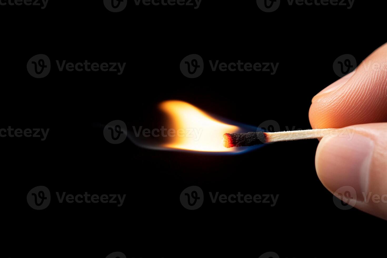 A person holding a matchstick with a lit match photo