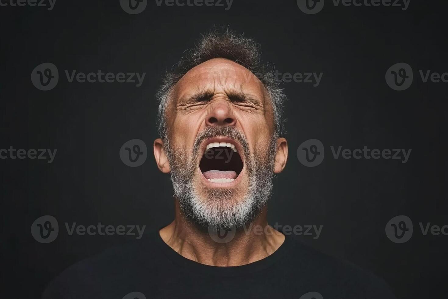 A man with a beard and a black shirt is screaming photo
