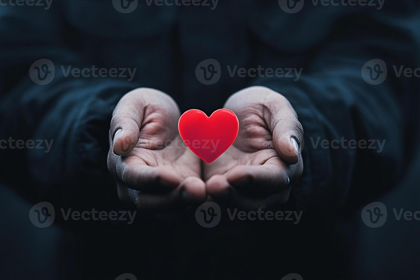 A person holding a red heart in their hands photo