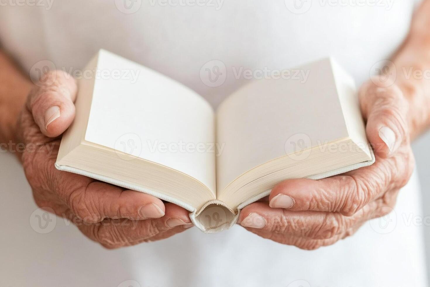 An elderly person holding an open book photo