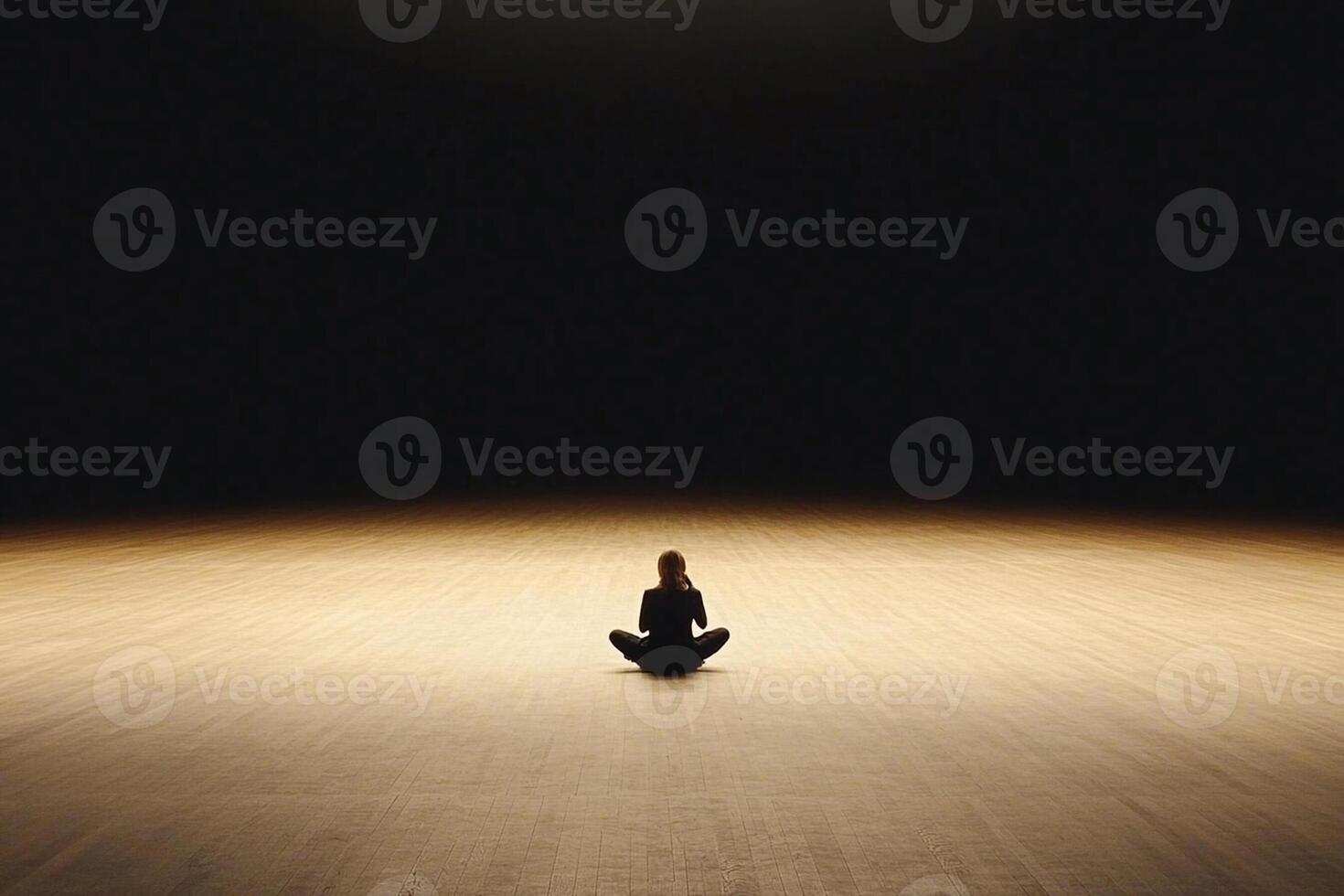 A person sitting in a dark room with a light shining on them photo
