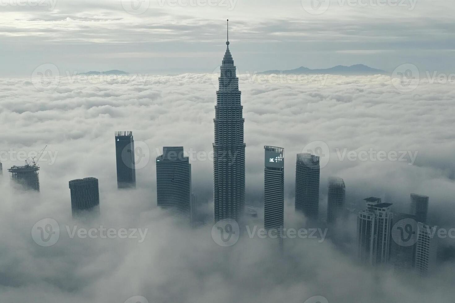 The kuala lumpur skyline is seen from above the clouds photo