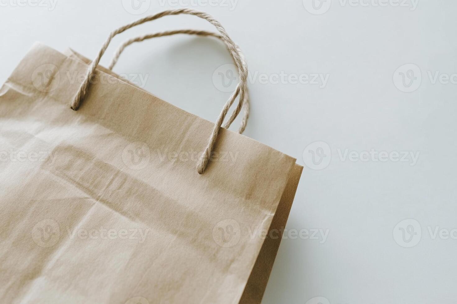 A brown paper bag with a handle on a white surface photo