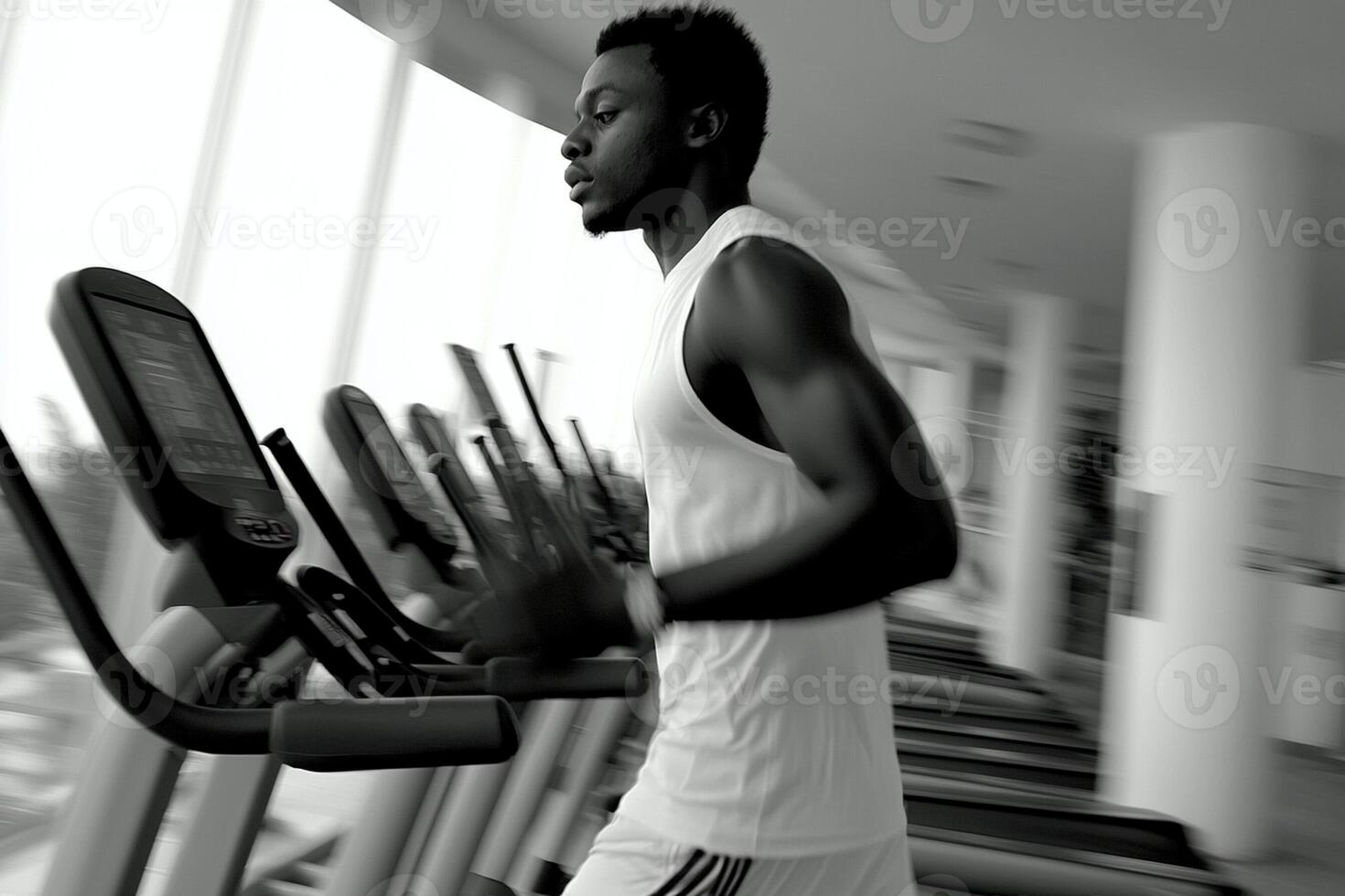 A man is running on a treadmill in a gym photo