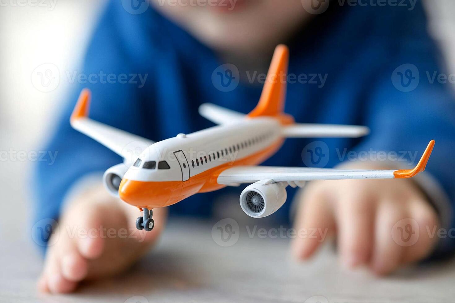 A child holding a toy airplane on a table photo