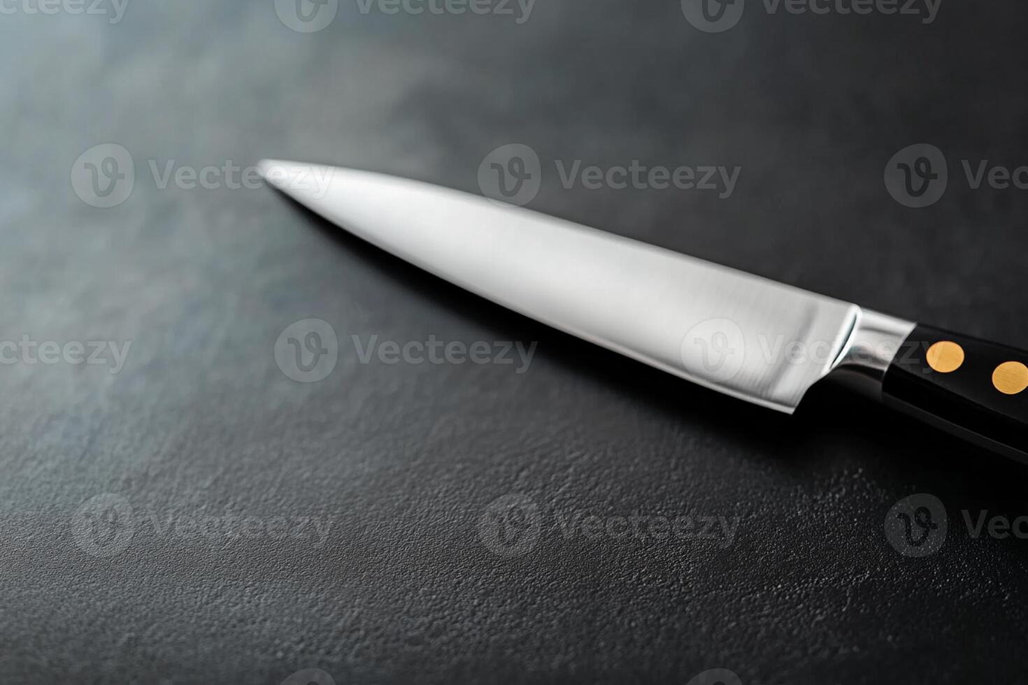 A knife on a black surface with a black background photo