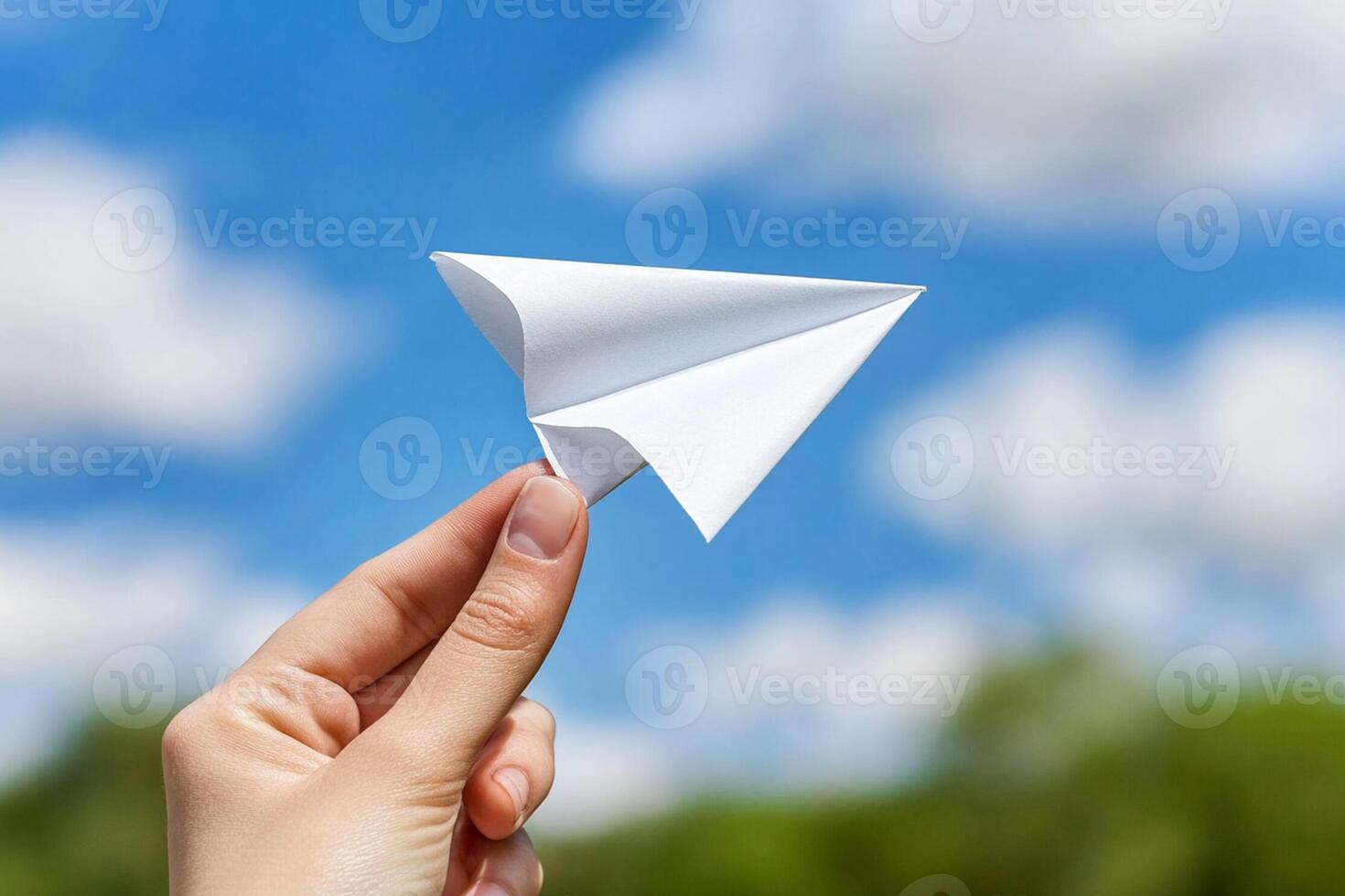 A person holding a paper airplane in their hand photo