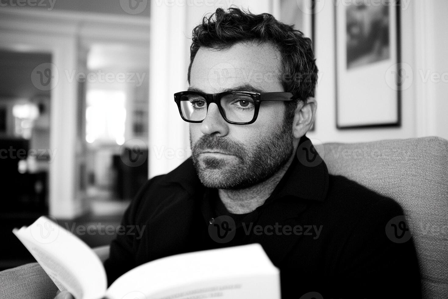 A man wearing glasses is reading a book photo