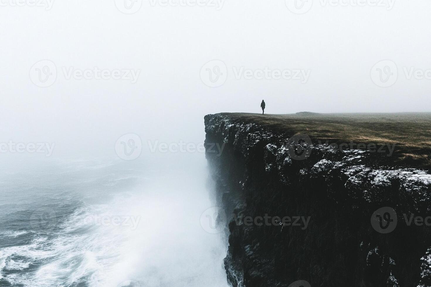 A person standing on the edge of a cliff photo
