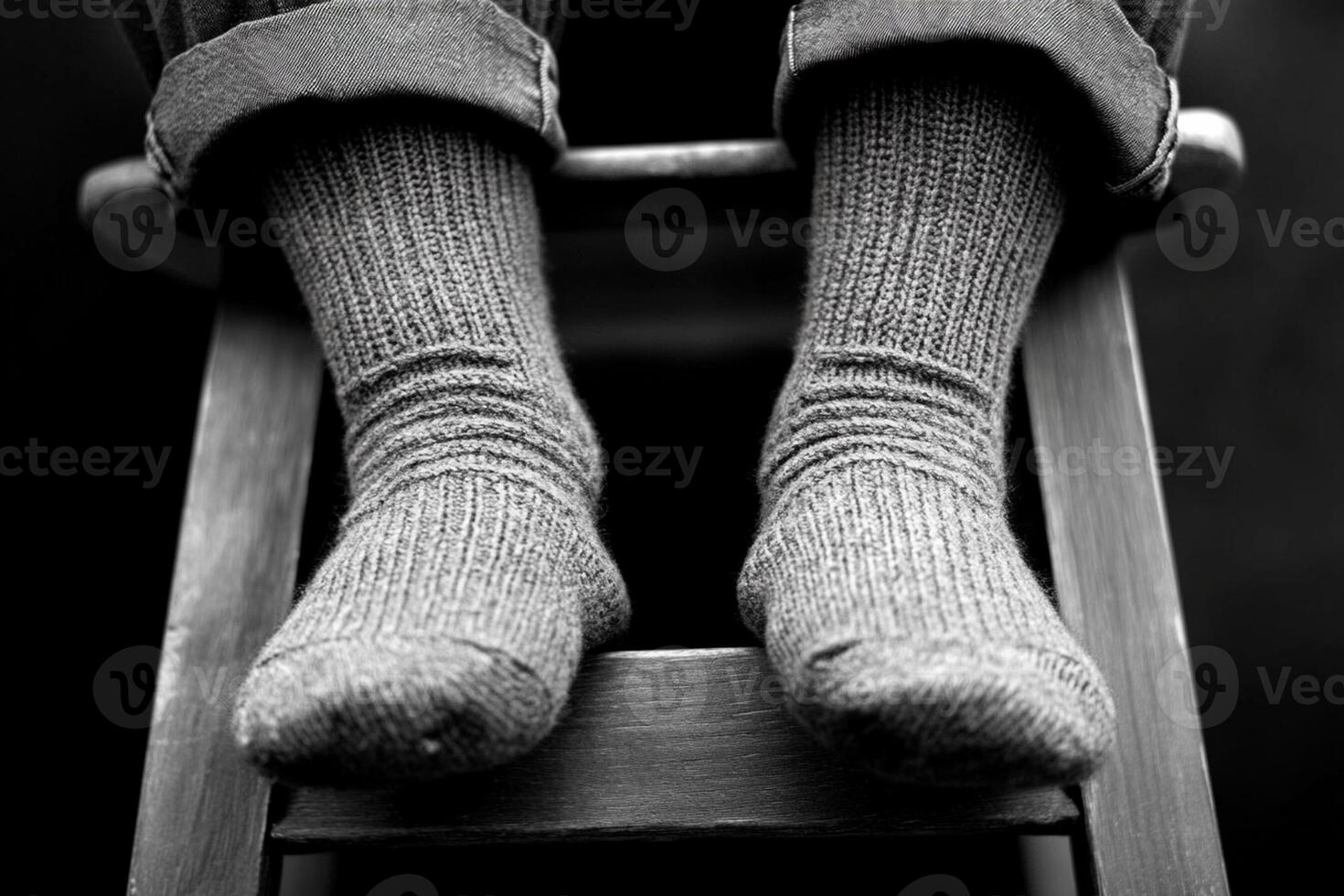 A person sitting on a chair with their feet in socks photo