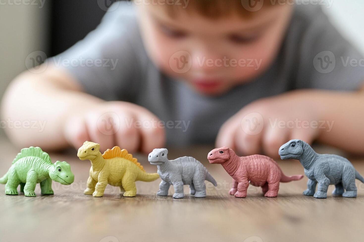 A child playing with toy dinosaurs on a table photo