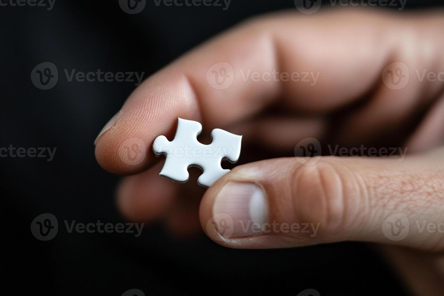 A person holding a piece of white puzzle photo