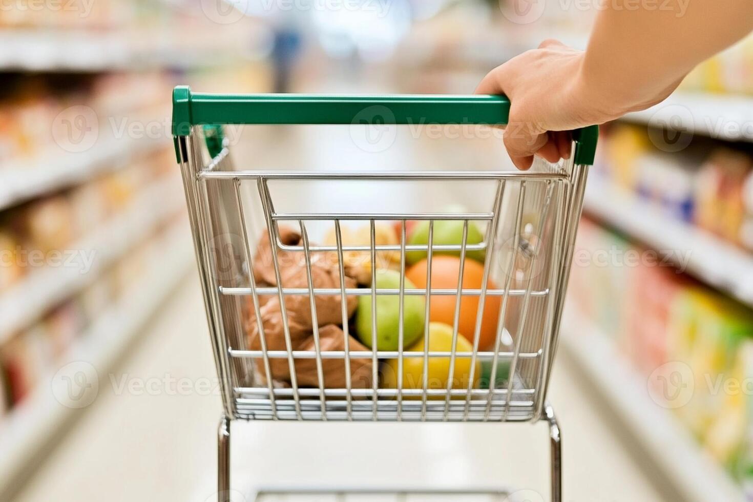 A person is holding a shopping cart with fruit and vegetables photo