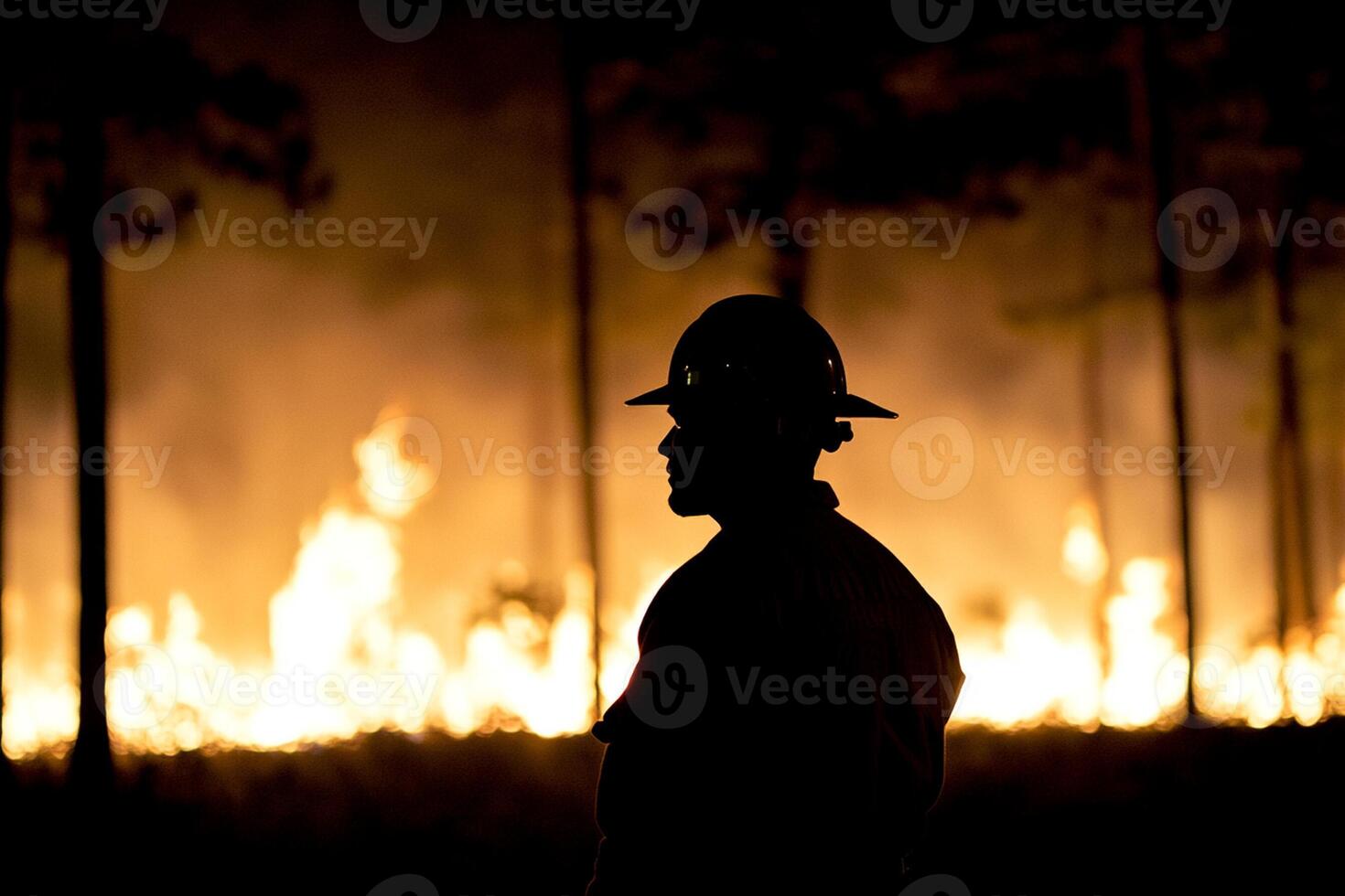A firefighter stands in front of a fire photo