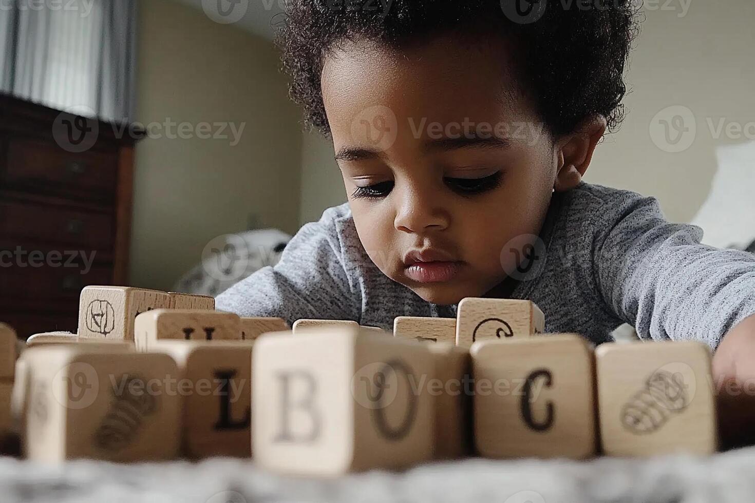 A young boy playing with blocks on the floor photo