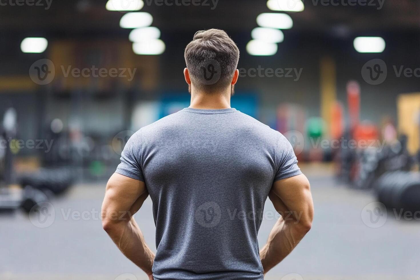 A man in a gym looking at his back photo