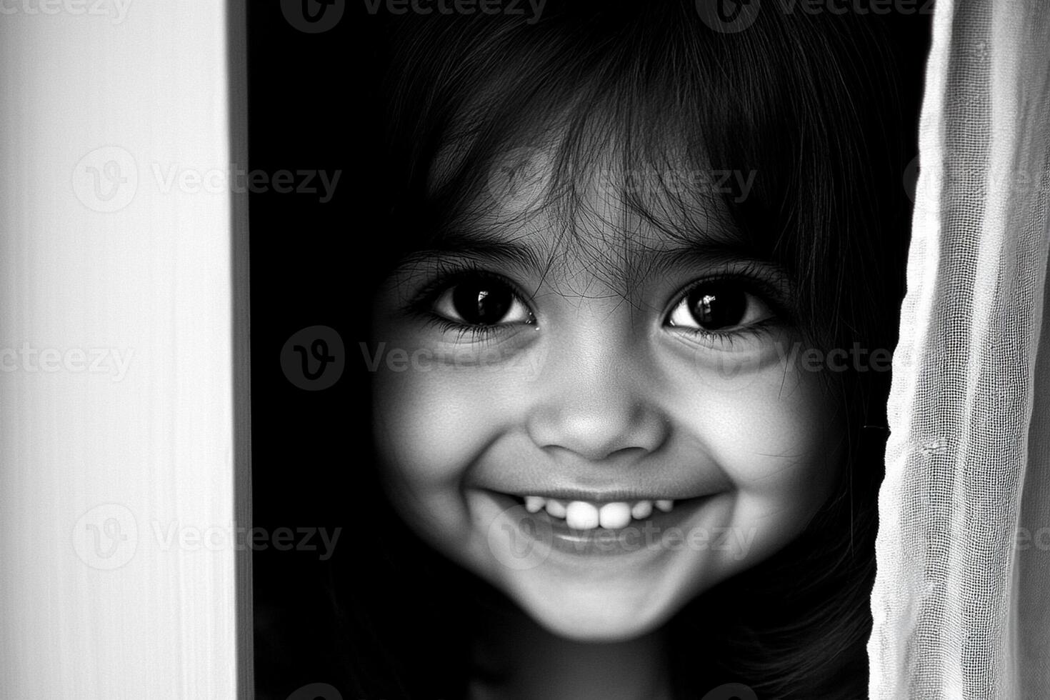 A black and white photo of a little girl smiling