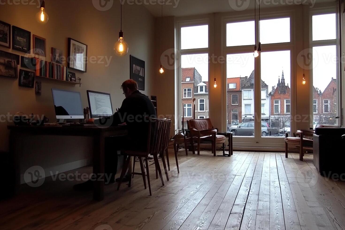 A man sitting at a desk in front of a window photo