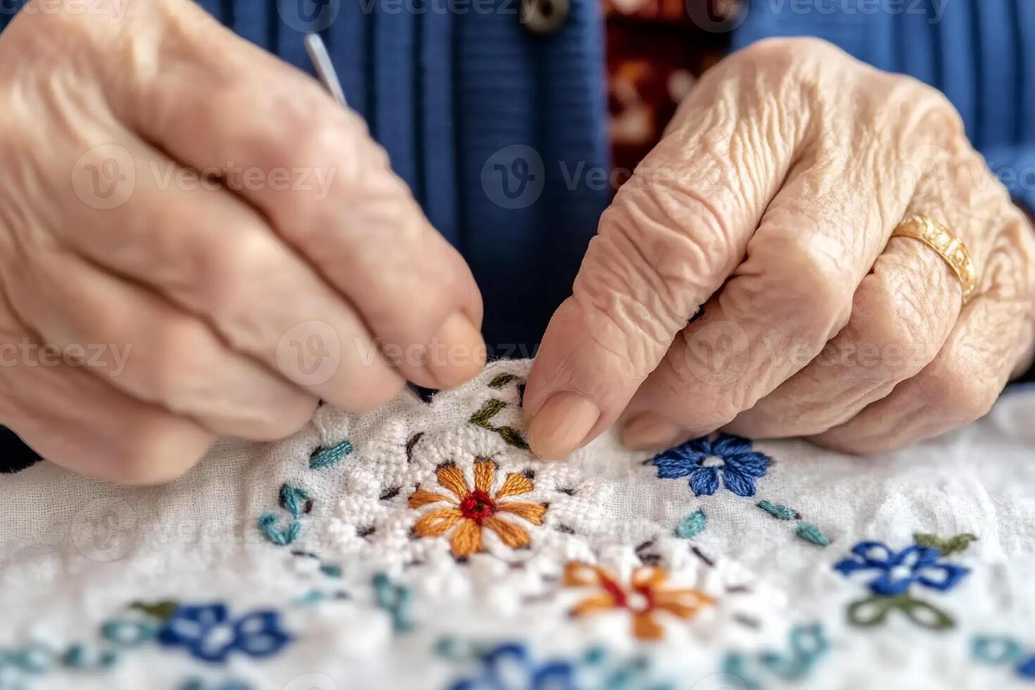An elderly woman is sewing a piece of embroidery photo