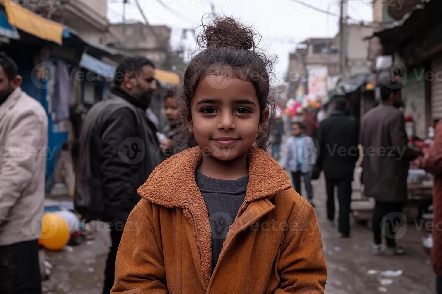 A young girl smiles for the camera in a crowded market photo