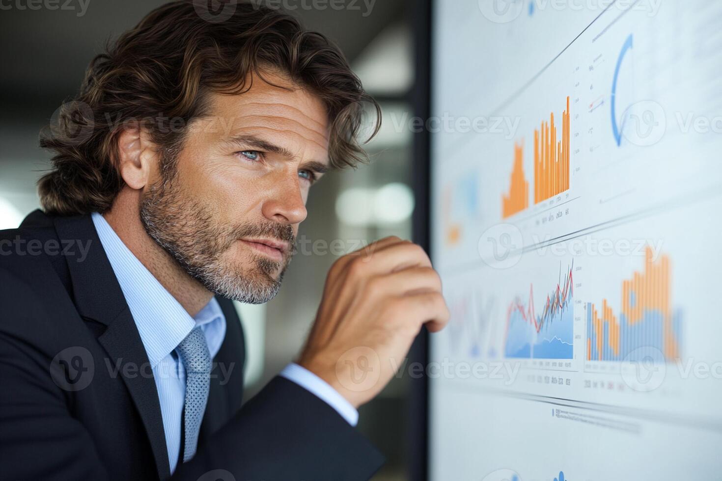 A man in a suit looking at a screen with graphs photo
