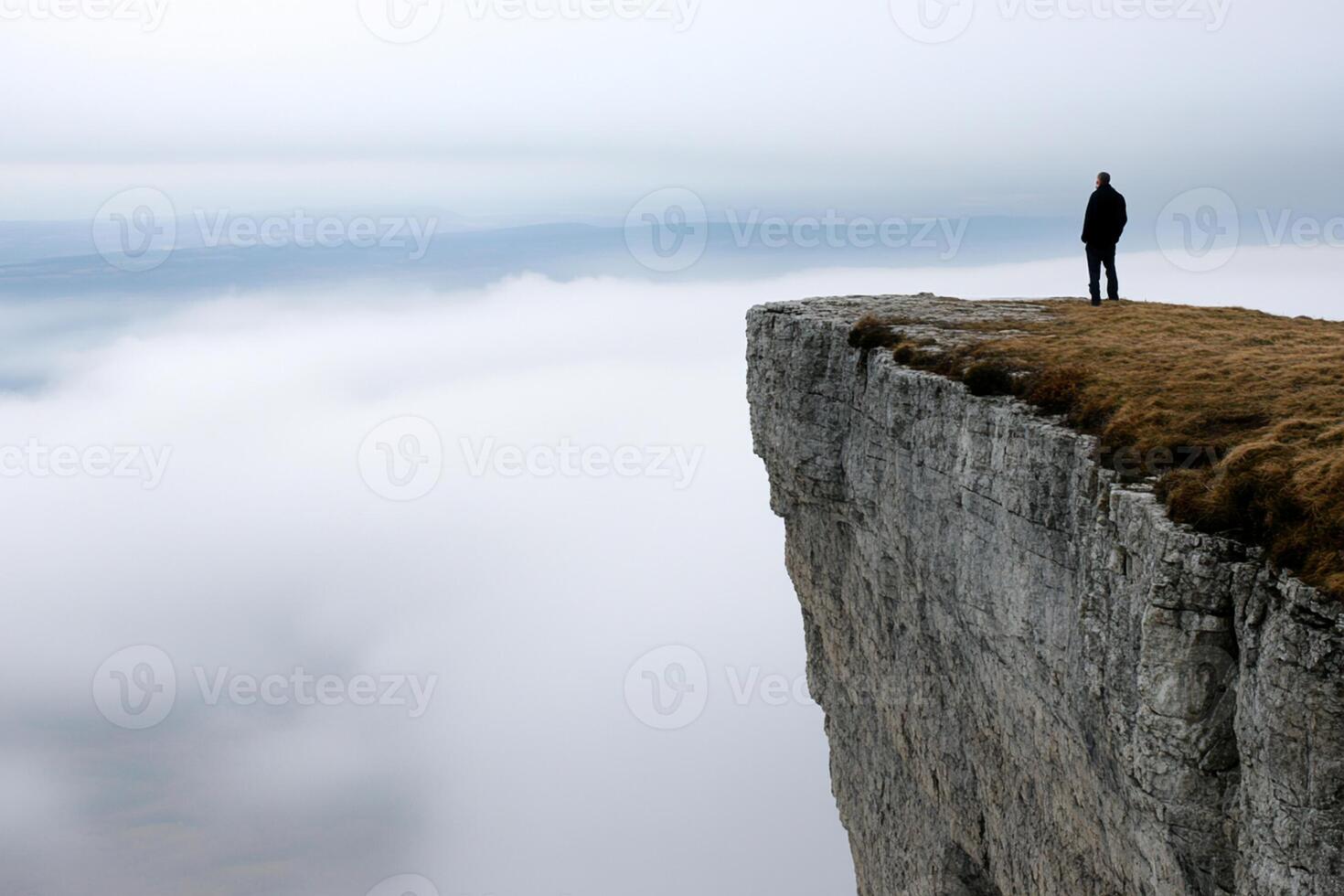 A person standing on a cliff overlooking a valley photo