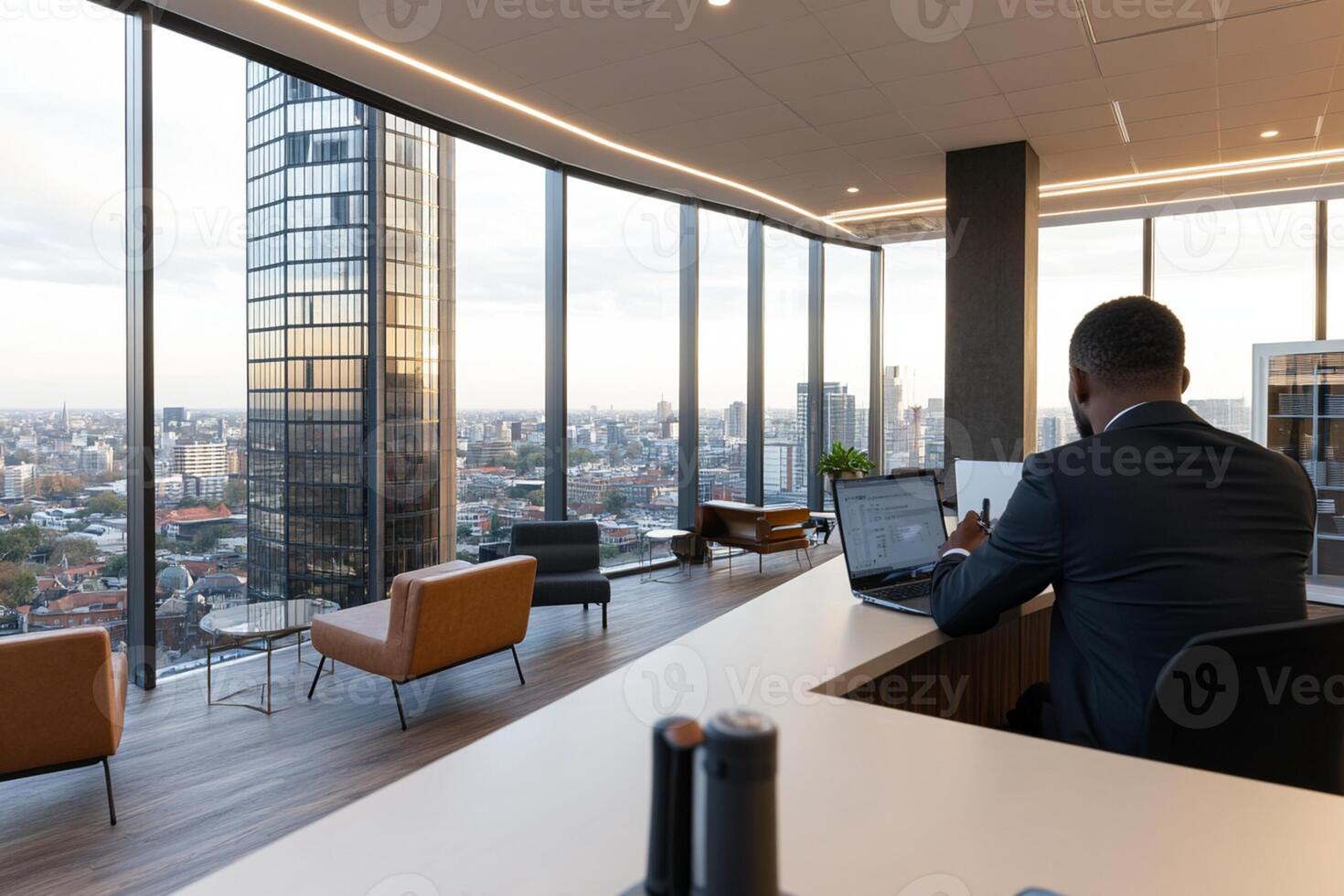 A man sitting at a desk in an office with a view of the city photo