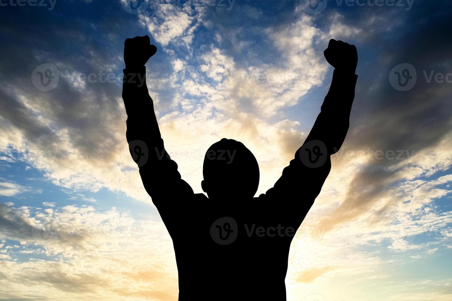 A man is silhouetted against a sky with clouds in the background photo