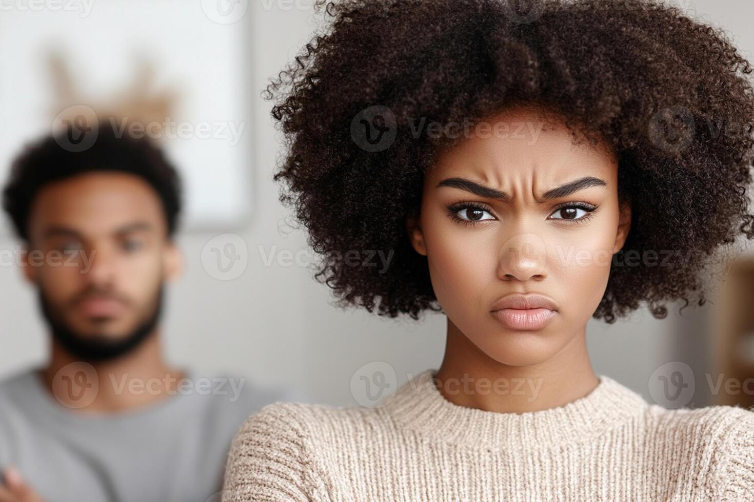 A woman with an angry expression and a man in the background photo