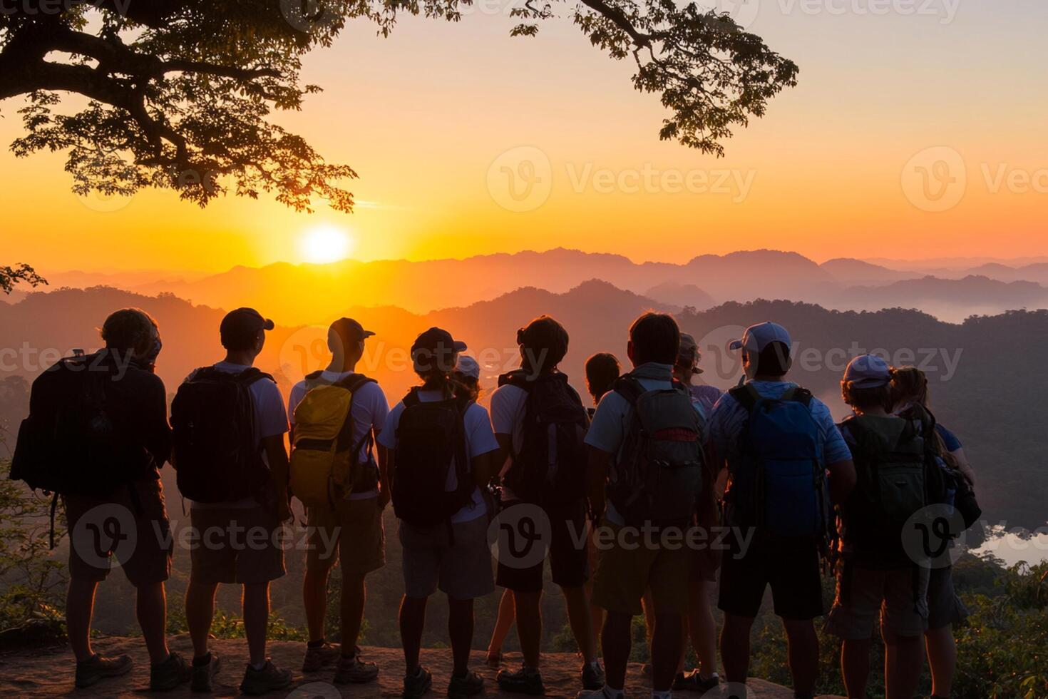 A group of people standing on a mountain at sunset photo
