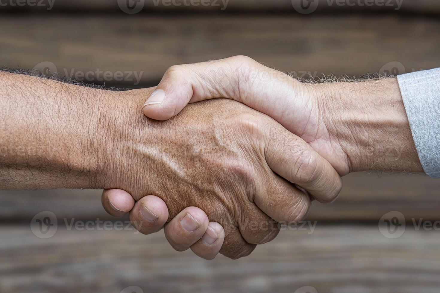 Two people shaking hands over a wooden background photo
