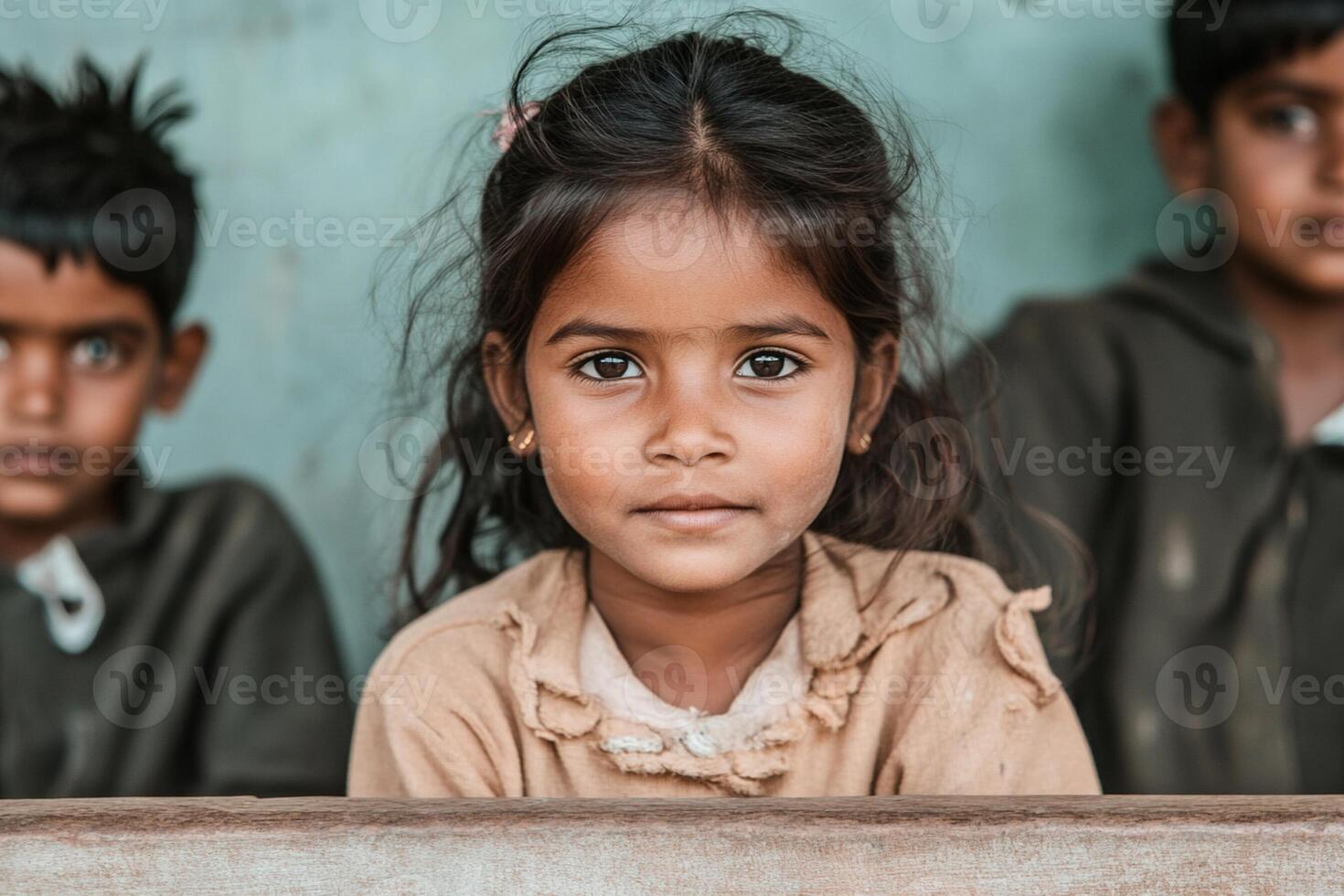 A young girl is sitting in front of a group of children photo