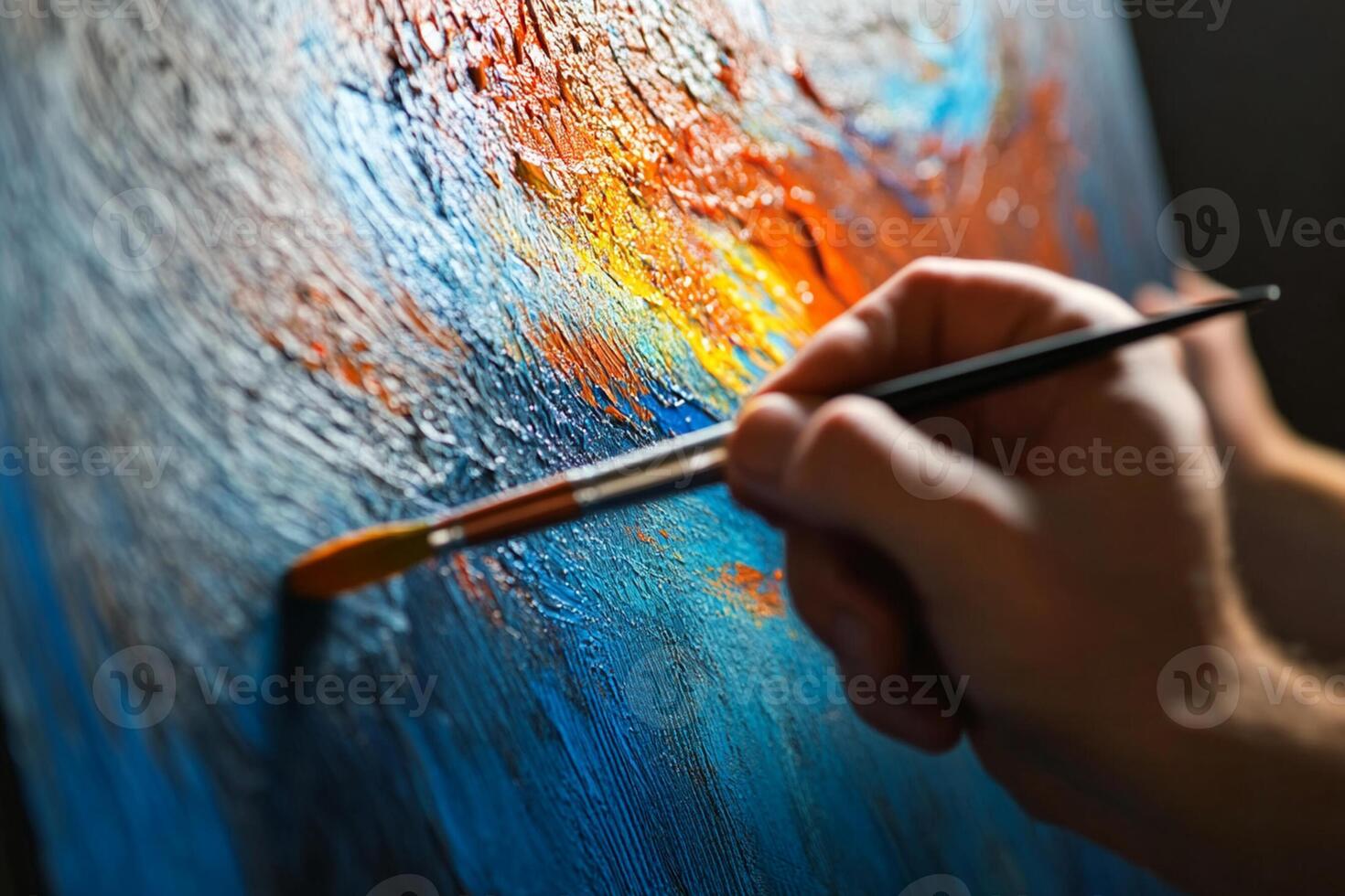 A person is holding a brush and painting on a canvas photo